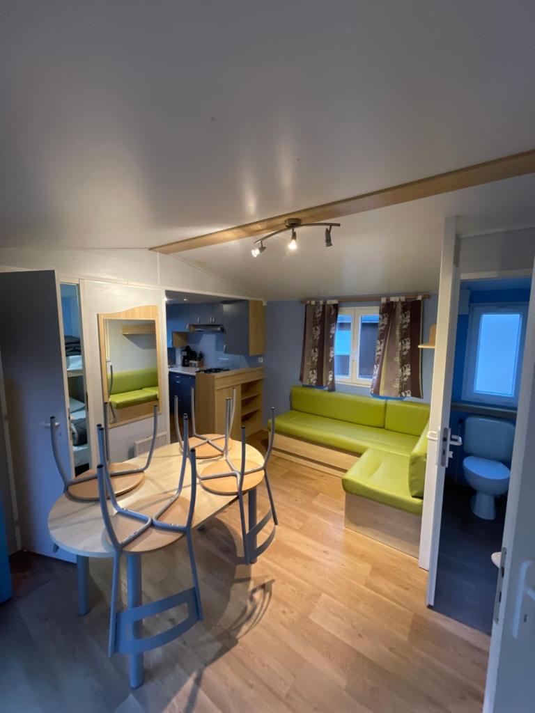 - un salon avec une table et un canapé vert dans l'établissement Camping les Portes du Perche, à Mamers 28 autres photos