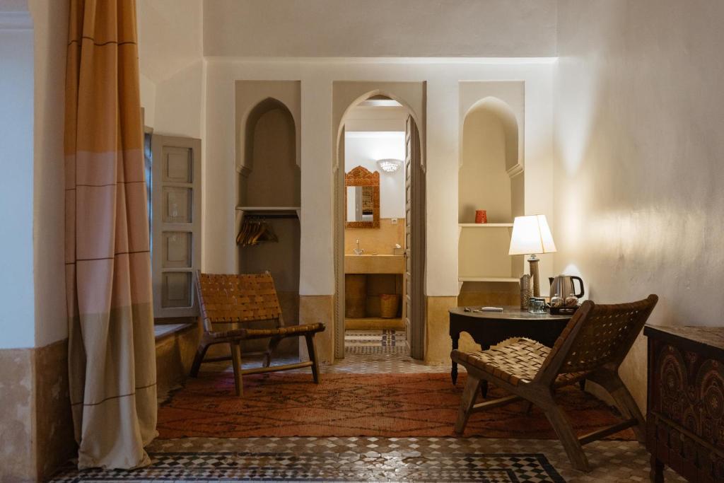 - un salon avec une table, des chaises et un bureau dans l'établissement Dar Lalla F'dila, à Marrakech 37 autres photos