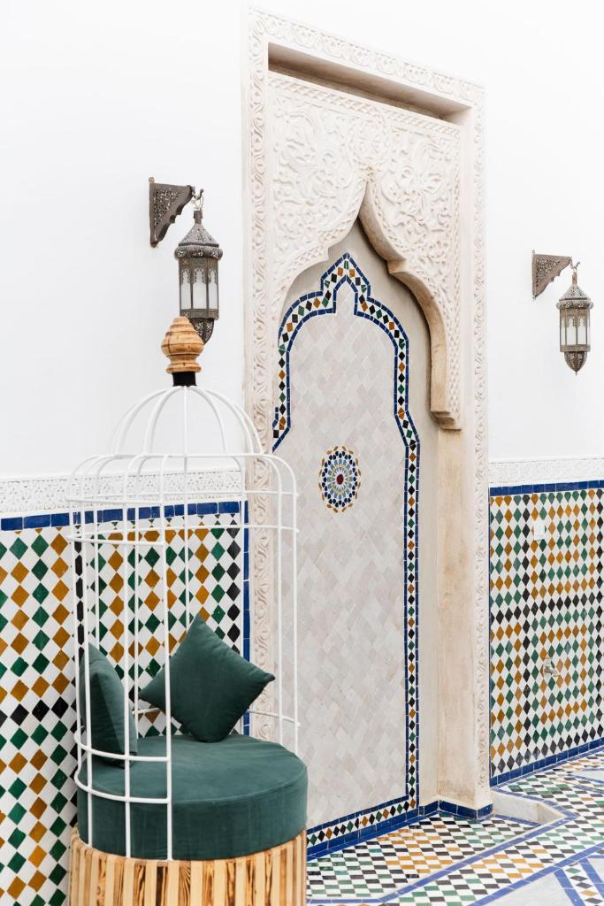 une chambre avec une chaise verte en face d'une mosquée dans l'établissement Riad Twilight, à Marrakech