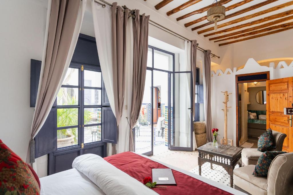 un salon avec un lit et une grande fenêtre dans l'établissement Riad Twilight, à Marrakech