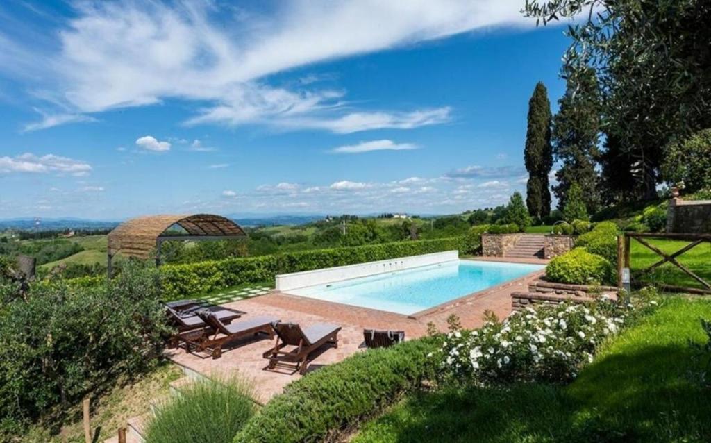 une piscine dans un jardin avec des chaises dans l'établissement Villa Vittoria Tuscany new opening 2025, à Montaione
