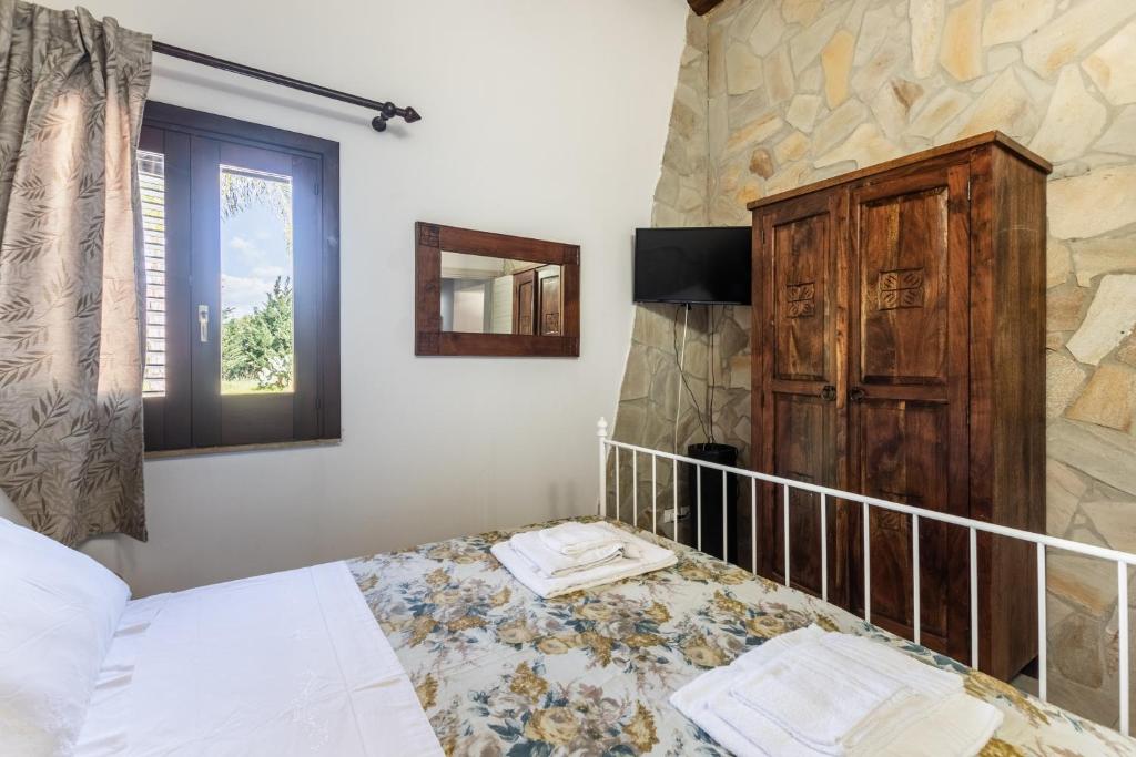 une chambre avec un lit, une fenêtre et un miroir dans l'établissement Rifugio del Sole, à Noto 26 autres photos