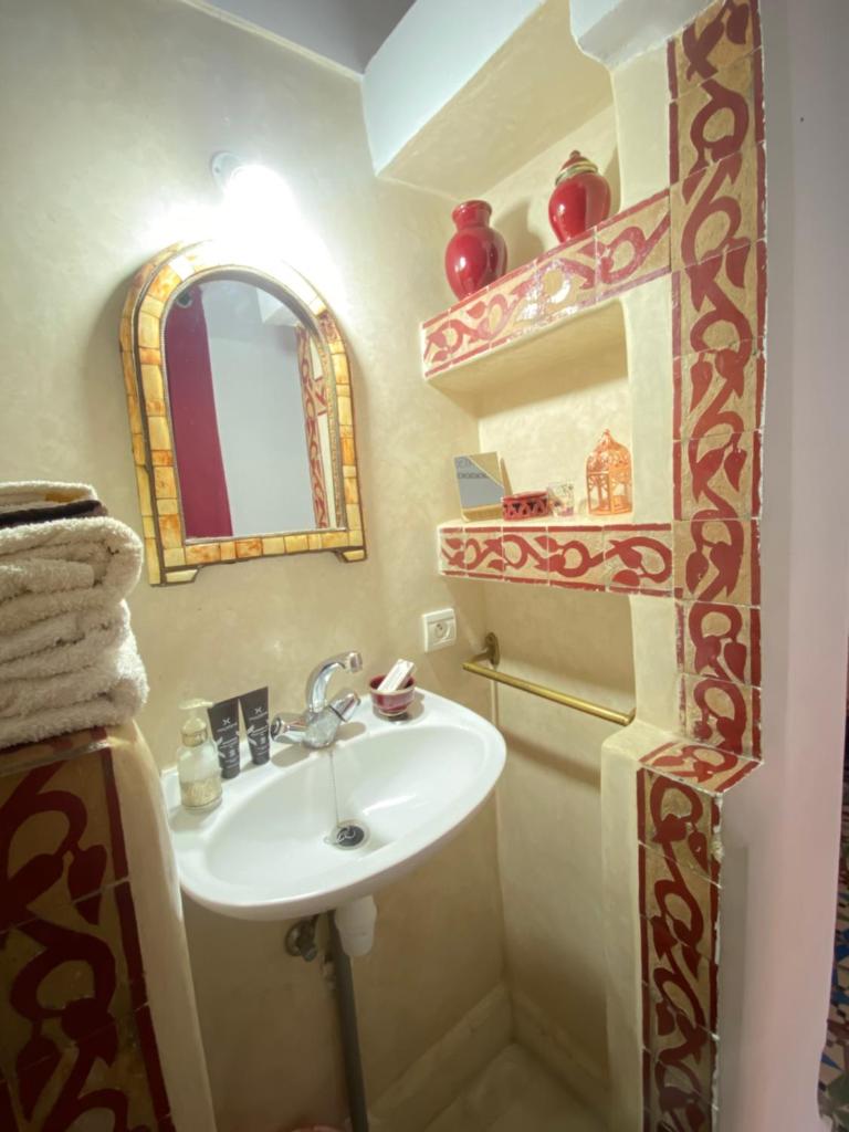 une salle de bain avec un lavabo et un miroir dans l'établissement Dar Sarah-Mouassine-Marrakech, Riad authentique idéalement situé, à Marrakech