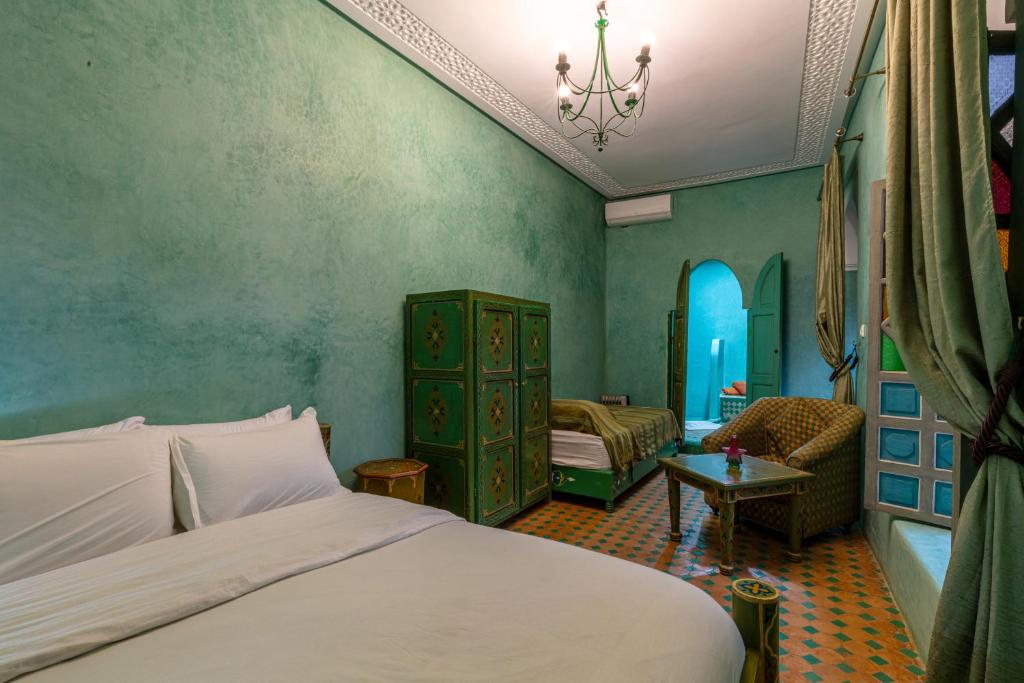 une chambre avec un lit et une chaise dans une pièce dans l'établissement Riad Zinoun & Spa 11 Rooms, à Marrakech