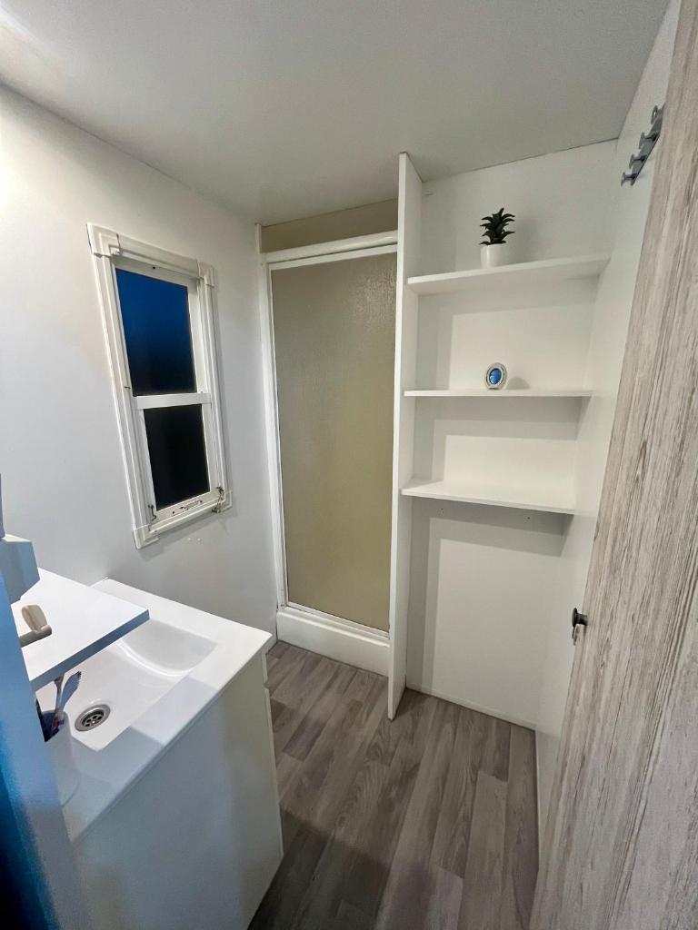 une salle de bain avec un lavabo et une fenêtre dans l'établissement terrain avec Mobil-Home, à Sommières