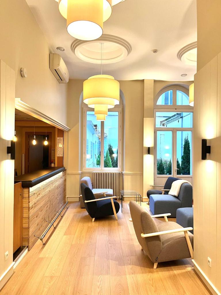 - un grand salon avec des canapés et des chaises dans l'établissement Hotel le Sacca, nouvelle équipe, à Cauterets