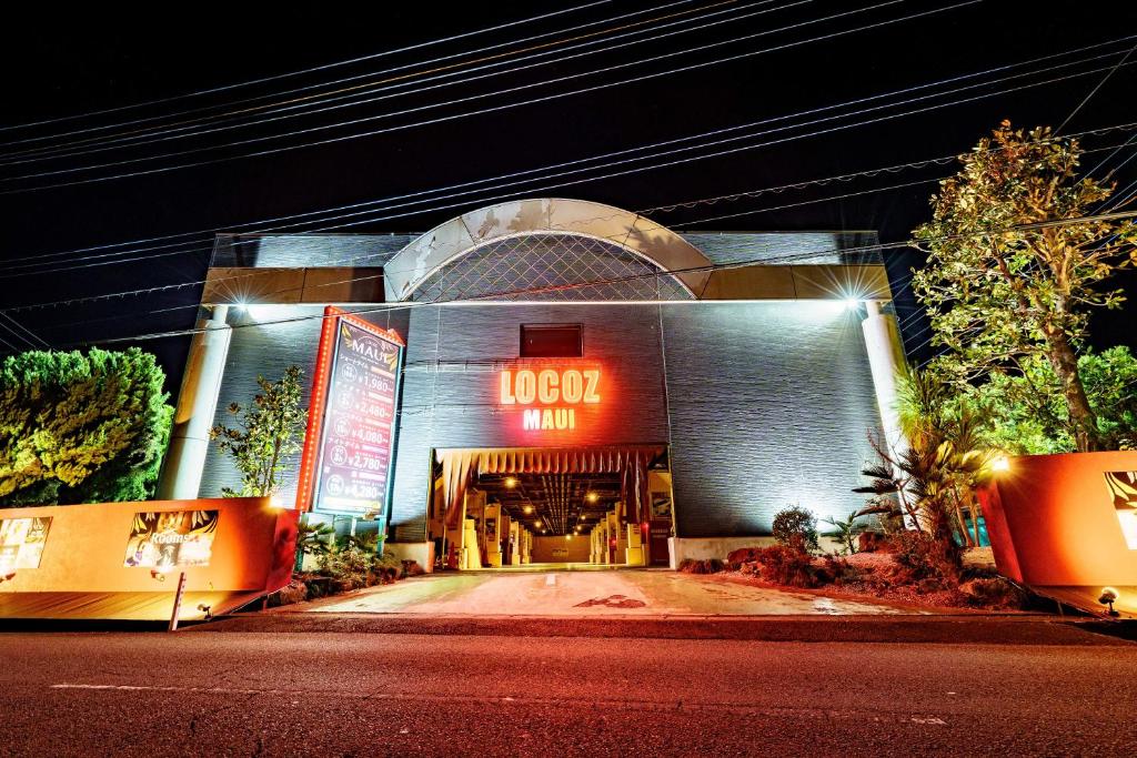 un bâtiment avec un panneau indiquant l'auberge de l'hôtel dans l'établissement ホテルロコズマウイ, à Honjo