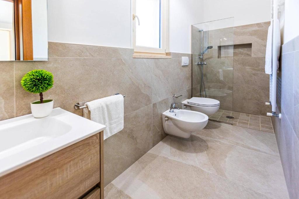 une salle de bain avec toilettes, lavabo et douche dans l'établissement Villa Peppe by Villa Plus, à Carovigno 21 autres photos
