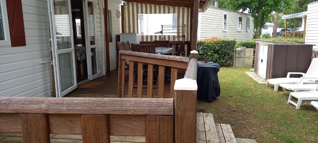 une clôture en bois sur une terrasse couverte d'une maison dans l'établissement MH372 camping Bois Dormant 6pers, à Saint-Jean-de-Monts