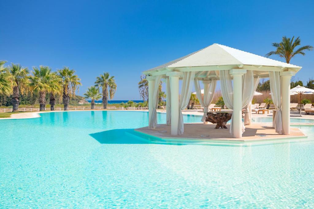 un kiosque au milieu d'une piscine dans l'établissement Spiagge San Pietro, a charming & relaxing resort, à Castiadas
