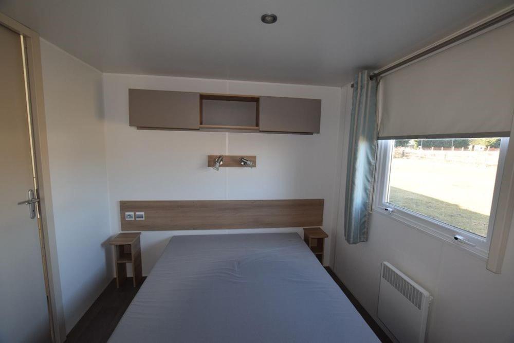 une petite chambre avec un lit et une fenêtre dans l'établissement Mazet 13, à Vias