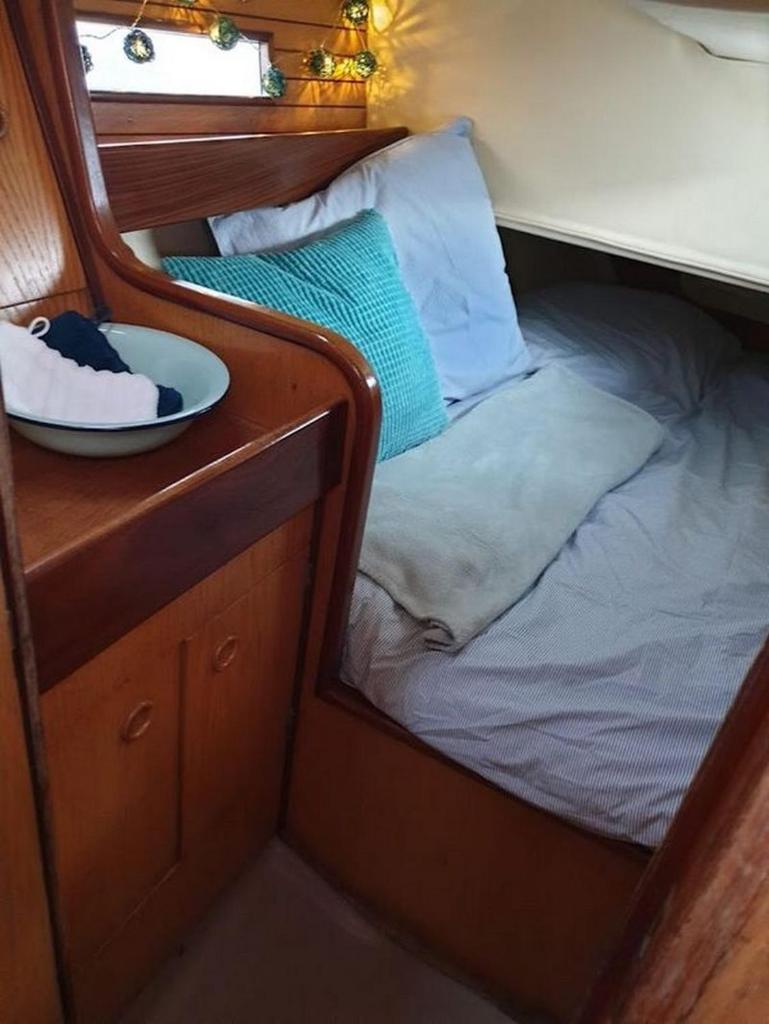 - un petit lit dans une chambre avec un bol sur une table dans l'établissement Le Snark, à Granville 2 autres photos