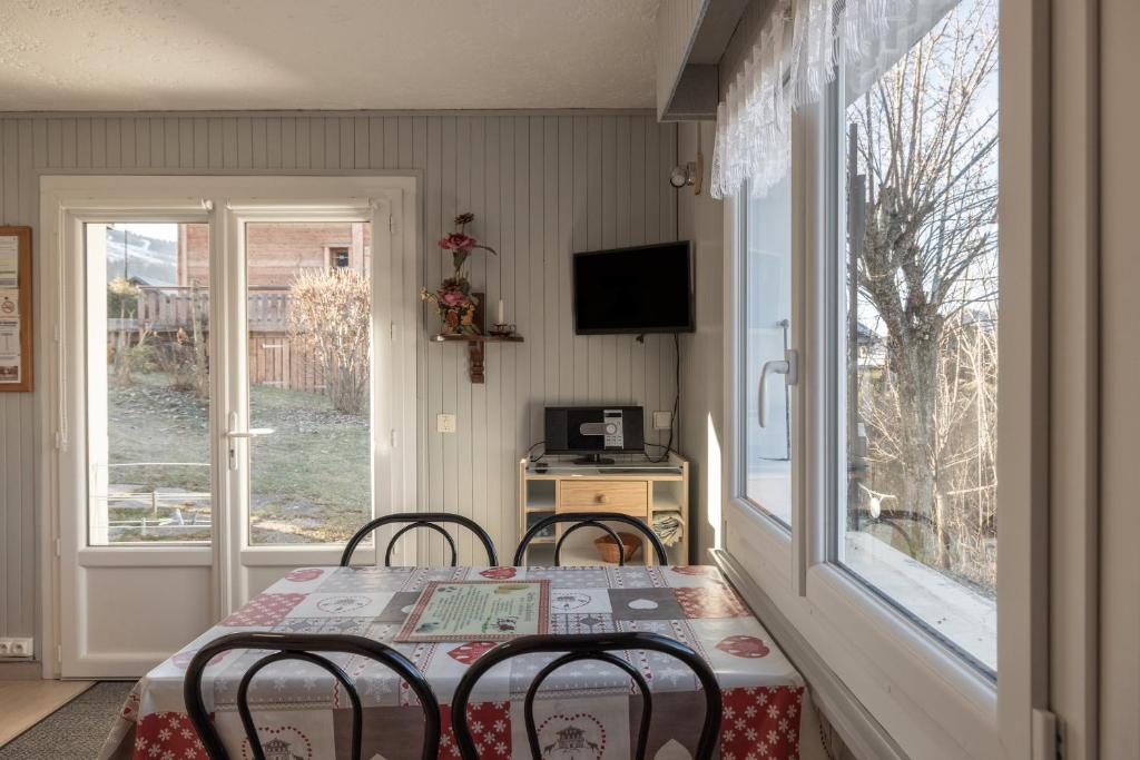 d'une salle à manger avec une table, deux chaises et une fenêtre. dans l'établissement Les Rocailles, à Notre-Dame-de-Bellecombe