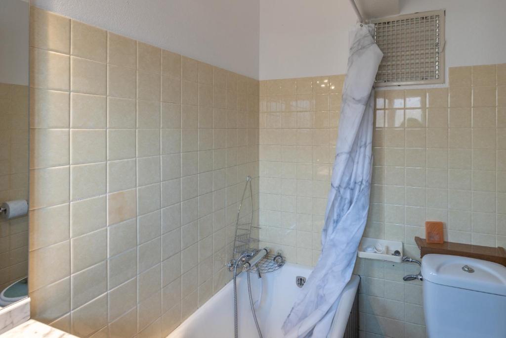 La salle de bains est pourvue d'un rideau de douche suspendu à une baignoire. dans l'établissement Les Rocailles, à Notre-Dame-de-Bellecombe 15 autres photos