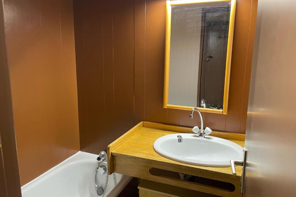 une salle de bain avec un lavabo, un miroir et une baignoire dans l'établissement Beautiful T2 near the slopes, à Saint-Chaffrey 1 autre photo