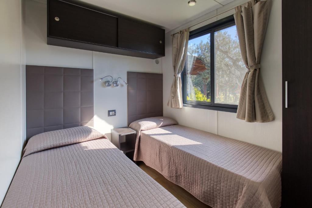 deux lits dans une chambre avec une fenêtre dans l'établissement Grotta del Saraceno, à Vasto