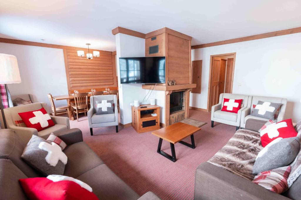 un salon avec un canapé, des chaises et une télévision dans l'établissement Le Grand Ours - Ski in ski out 4 bed chalet, Arc 1950, à Arc 1950