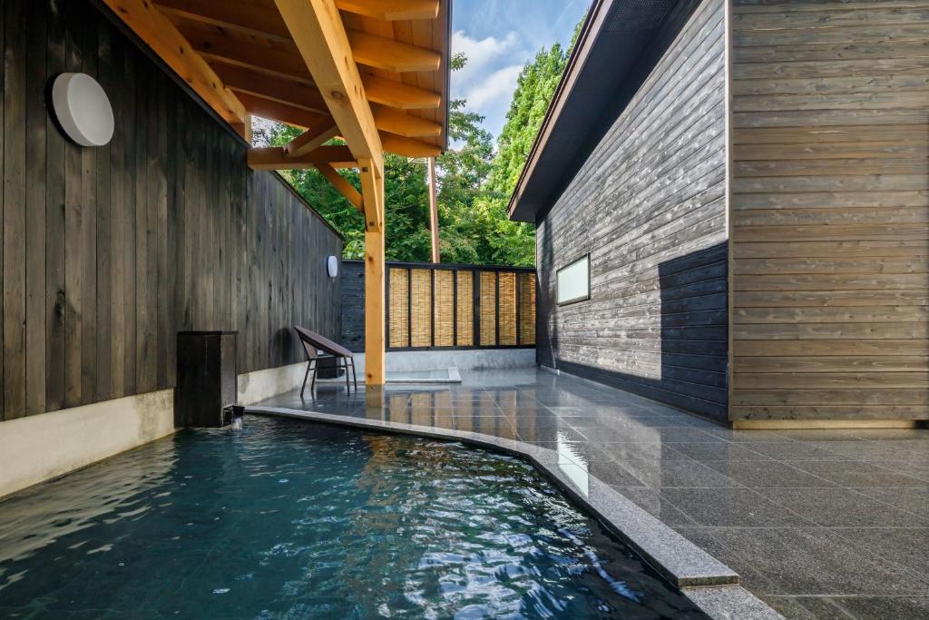 une piscine au milieu d'une maison dans l'établissement 田沢湖水沢温泉郷セルリアンリゾートAoni, à Senboku