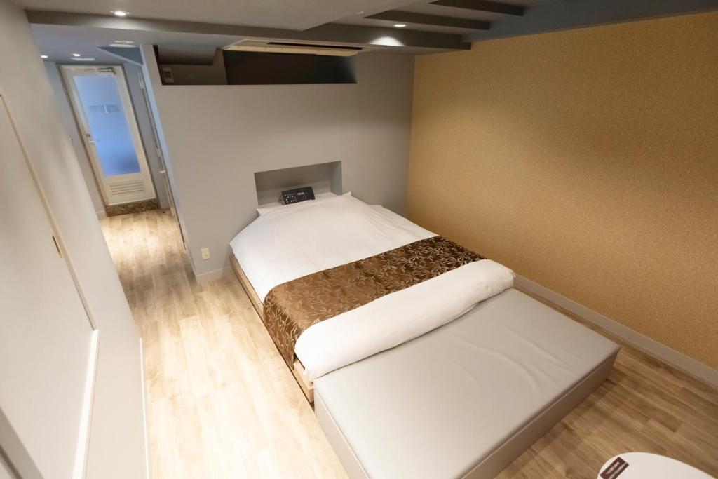 une petite chambre avec un lit et une fenêtre dans l'établissement HOTEL ATLAS Shinkabukicho (Adult Only), à Tokyo