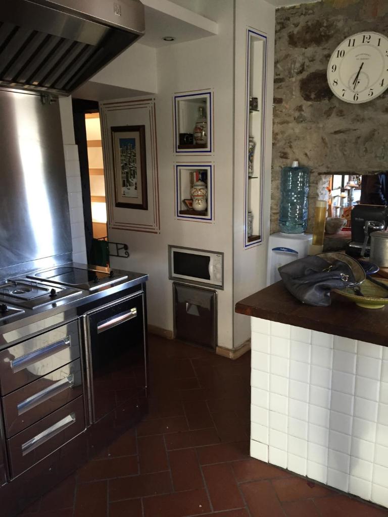 une cuisine avec une cuisinière et une horloge au mur dans l'établissement Casa Rea, à Beverino
