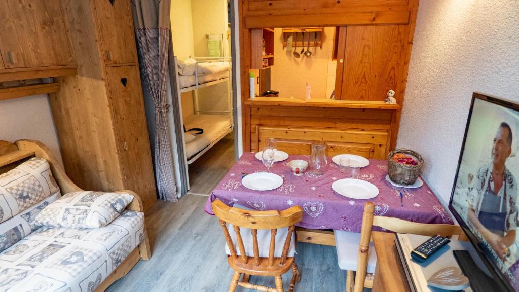 une salle à manger avec une table et un canapé dans l'établissement Magnifique studio au pied du télécabine d'Arrondaz et des pistes de ski, à Modane