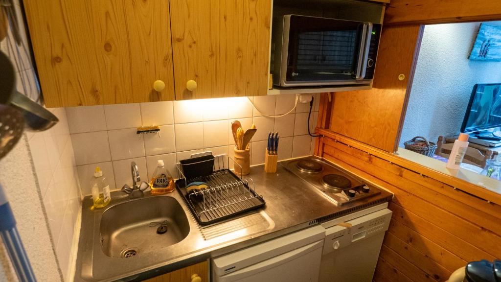 une cuisine avec un évier et un plan de travail dans l'établissement Magnifique studio au pied du télécabine d'Arrondaz et des pistes de ski, à Modane