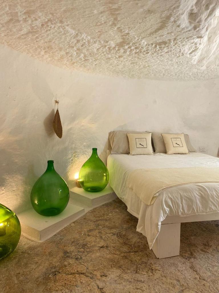 - une chambre avec deux vases verts à côté d'un lit dans l'établissement Le Sette Valli, à Selva di Fasano