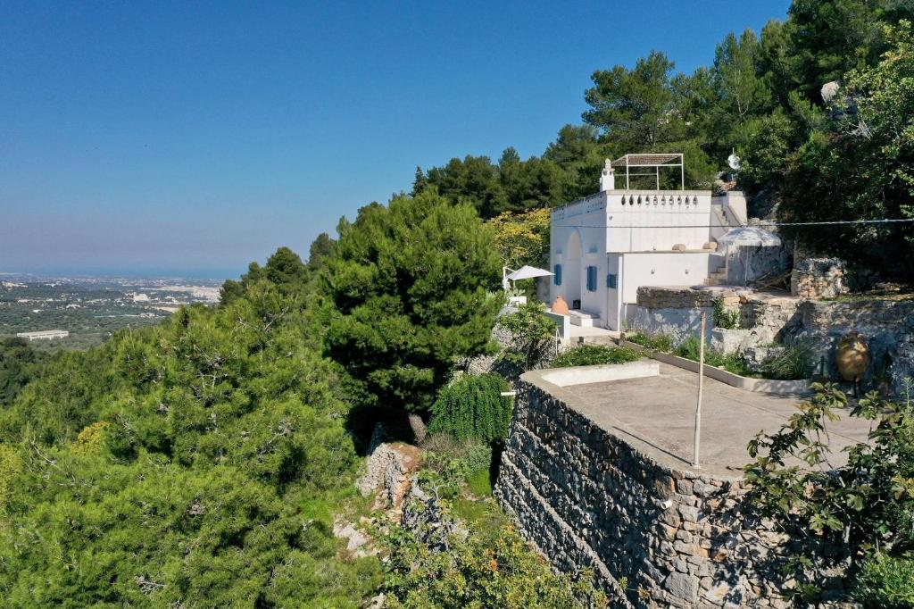 un bâtiment au sommet d'une colline avec des arbres dans l'établissement Le Sette Valli, à Selva di Fasano