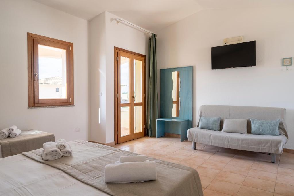 un salon avec deux lits et un canapé dans l'établissement Mimose Beach Village, à Badesi