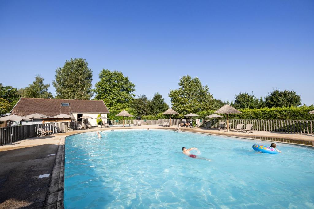 un groupe de personnes nageant dans une piscine dans l'établissement Huttopia La Plage Blanche, à Ounans