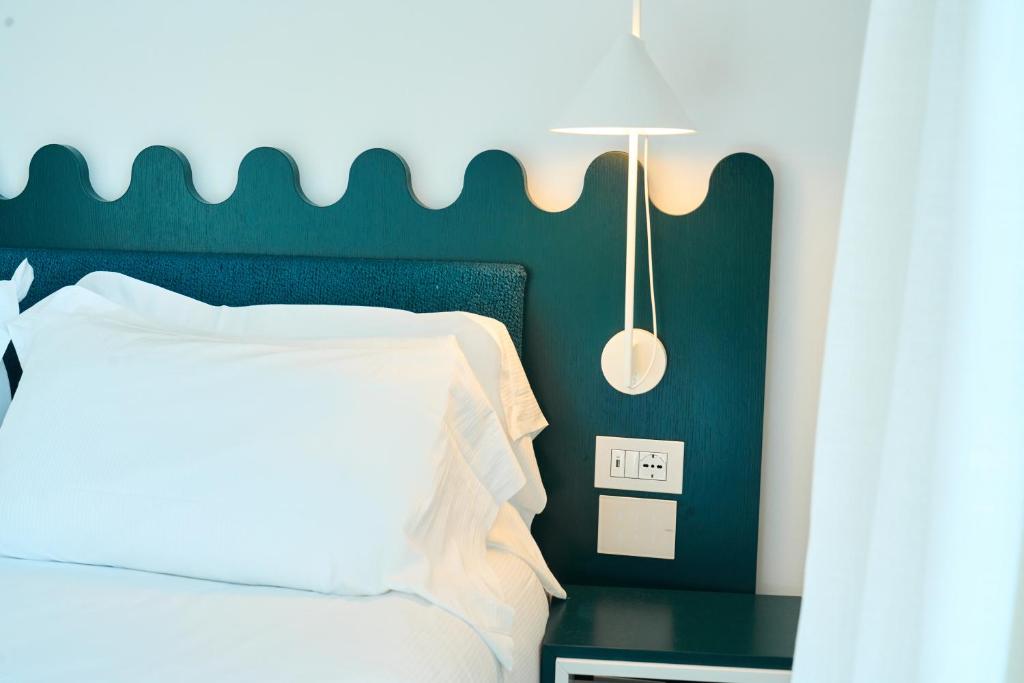 - une chambre avec un lit et une table avec une horloge dans l'établissement CALEA Boutique Hotel, à Bacoli