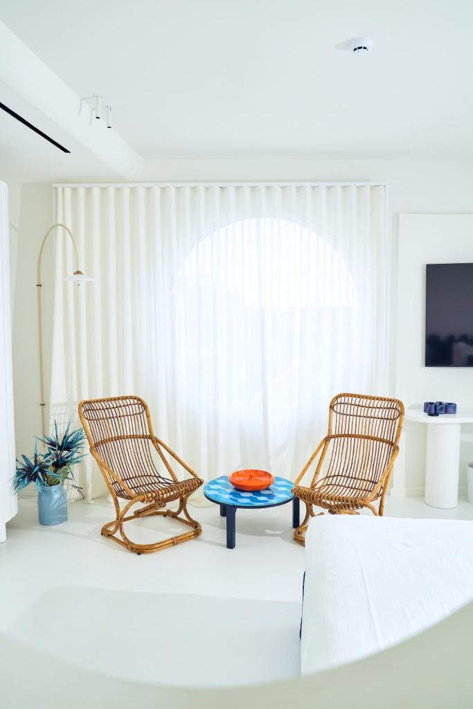 - deux chaises et une table dans le salon dans l'établissement CALEA Boutique Hotel, à Bacoli