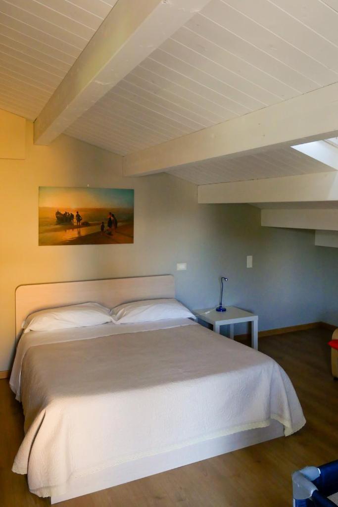 une chambre avec un grand lit blanc dans une pièce dans l'établissement Otium casa vacanze-servizio spiaggia incluso a 250 mt-struttura pet friendly, à Giulianova