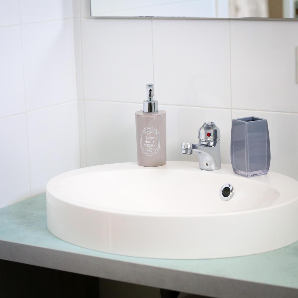un lavabo de salle de bain blanc avec un distributeur de savon dessus dans l'établissement Otium casa vacanze-servizio spiaggia incluso a 250 mt-struttura pet friendly, à Giulianova 123 autres photos