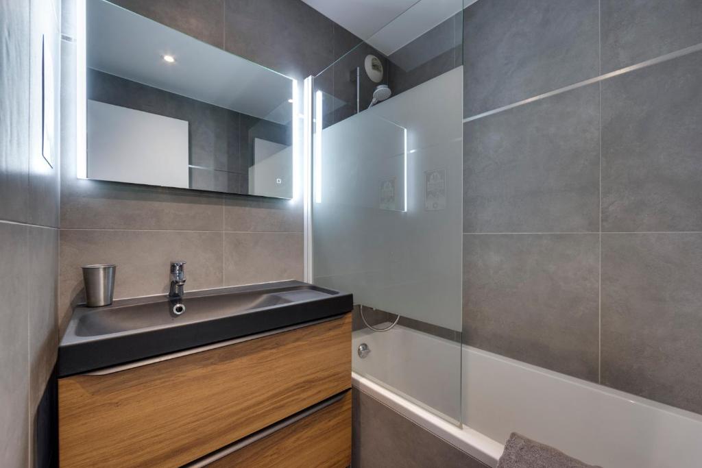 une salle de bain avec un lavabo et un miroir dans l'établissement Le Santel 199, à Val dʼIsère