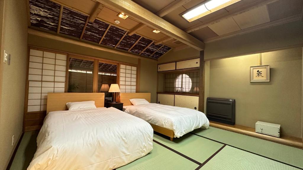- une chambre avec 2 lits et une télévision dans l'établissement Ryoutei Ryokan Takechiyo Kirishima Bettei, à Kirishima