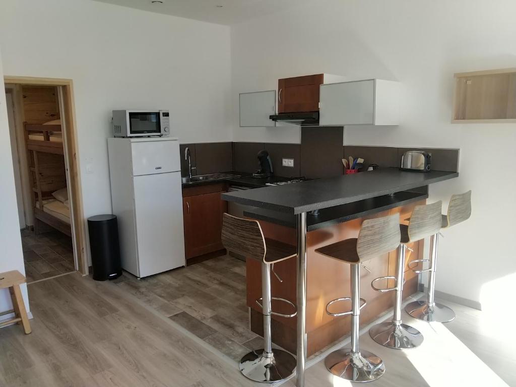 une cuisine avec un comptoir noir dans une pièce dans l'établissement Les Balcons de L'Izoard, à Arvieux 8 autres photos