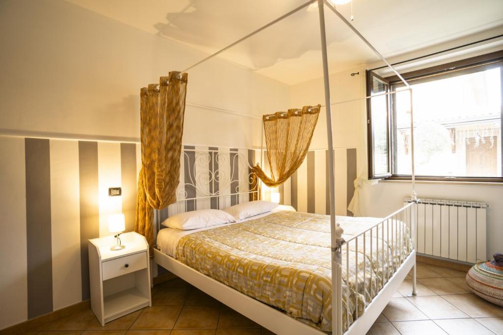 une chambre avec un lit à baldaquin et une fenêtre dans l'établissement Villa Patty, à Castelnuovo