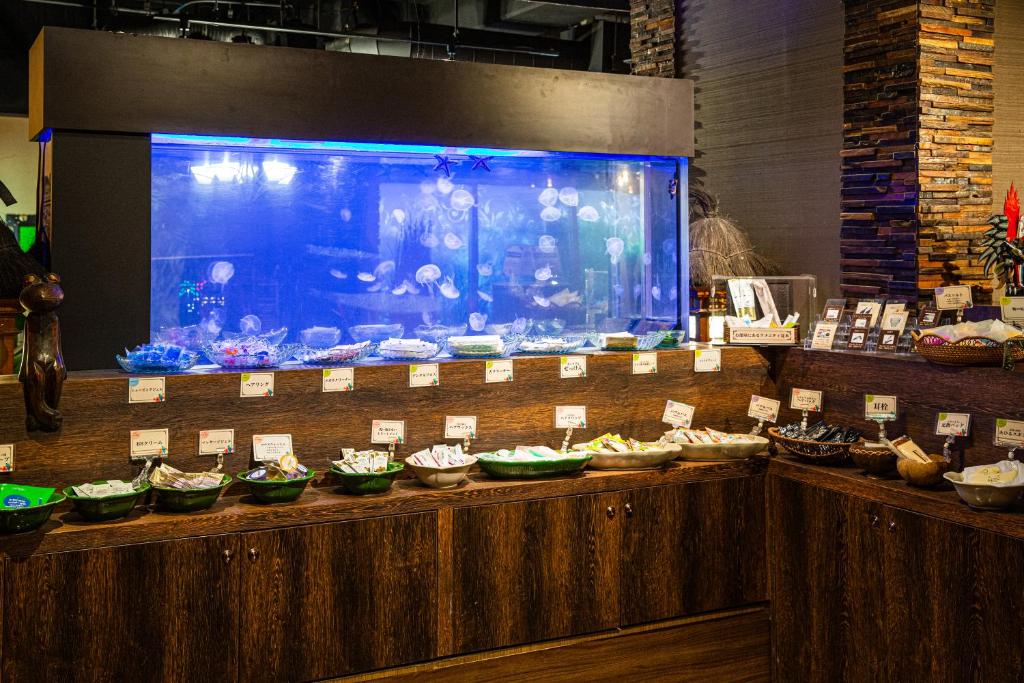 un buffet avec un grand aquarium et de nombreux bols de nourriture dans l'établissement Hotel Balian Resort Kinshicho, à Tokyo 39 autres photos
