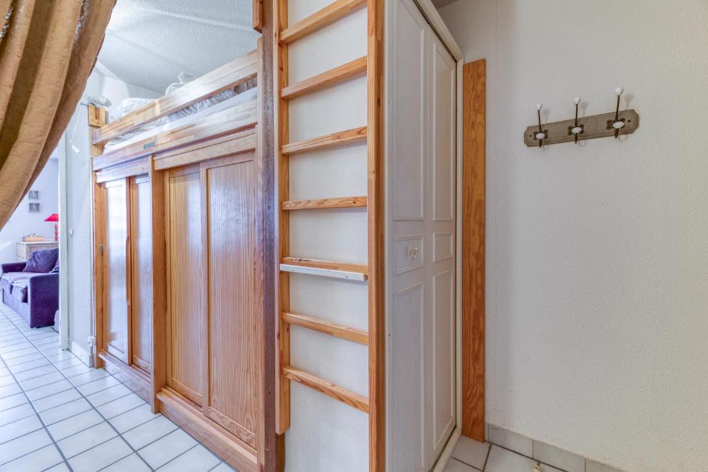 Cette chambre dispose d'un placard avec des étagères en bois. dans l'établissement Granges 25 - Au Pied Des Pistes, à Villard-Reculas