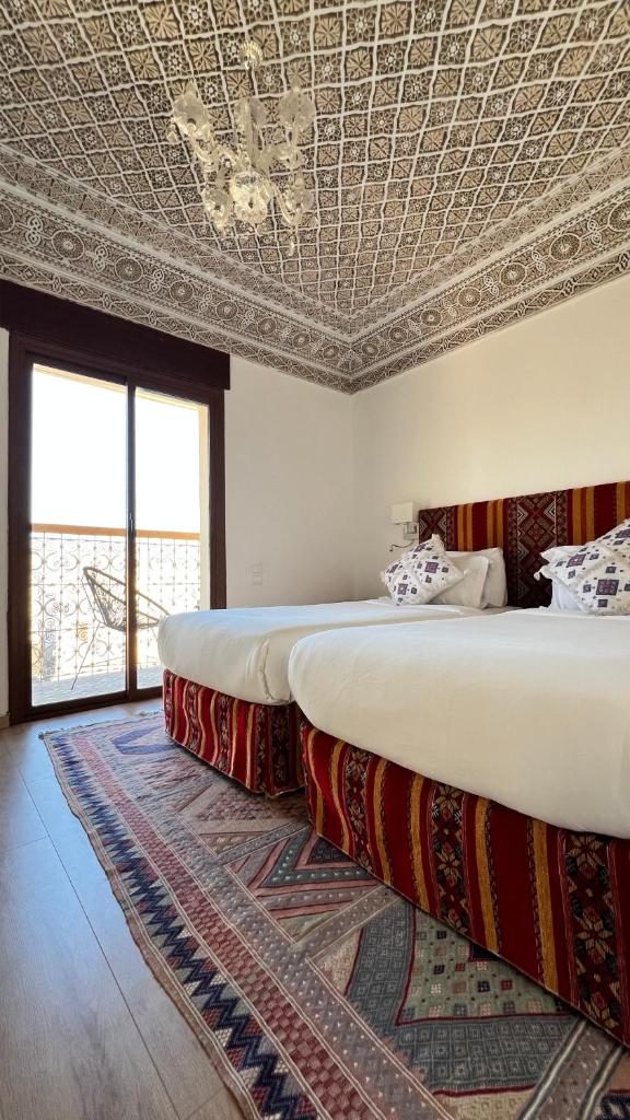 deux lits dans une chambre avec un plafond dans l'établissement Riad Fes Palacete, à Fès