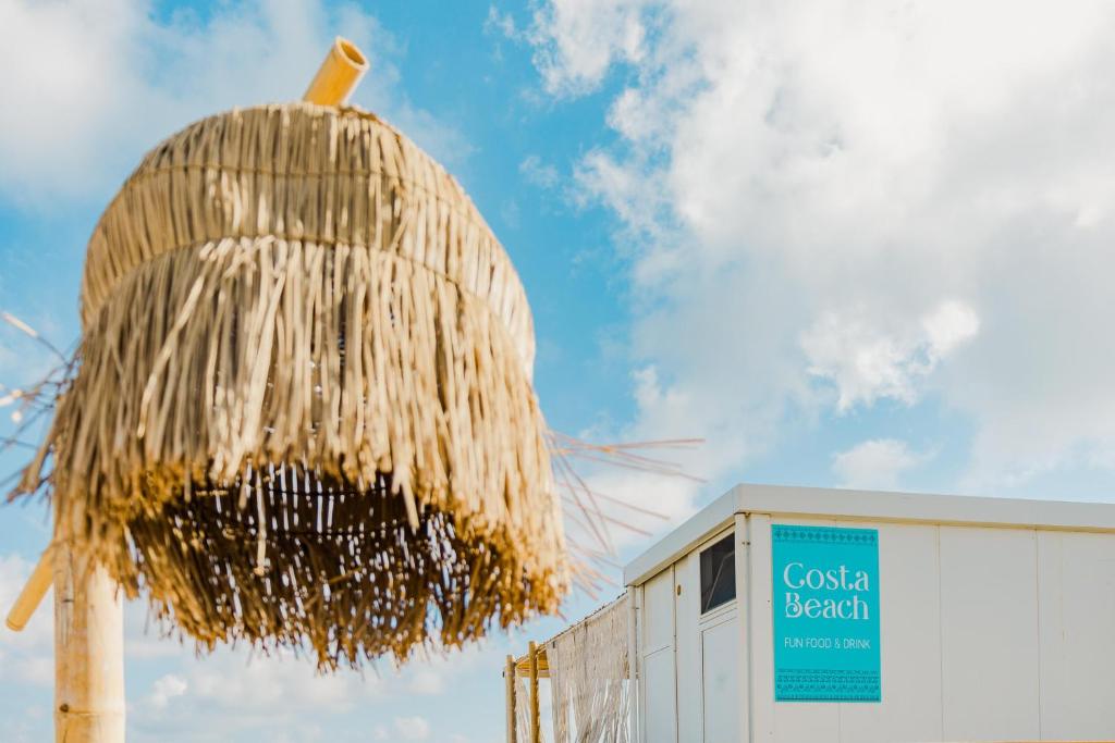 un bâtiment avec un panier de paille à côté d'un bâtiment dans l'établissement Costa del Salento - CDSHotels, à Lido Marini