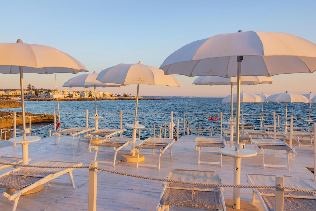 - une rangée de tables et de chaises avec parasols sur la plage dans l'établissement Grand Hotel Riviera - CDSHotels, à Santa Maria al Bagno