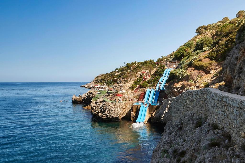 un groupe de toboggans sur le côté d'une falaise dans l'établissement CDSHotels Terrasini - Città del Mare, à Terrasini