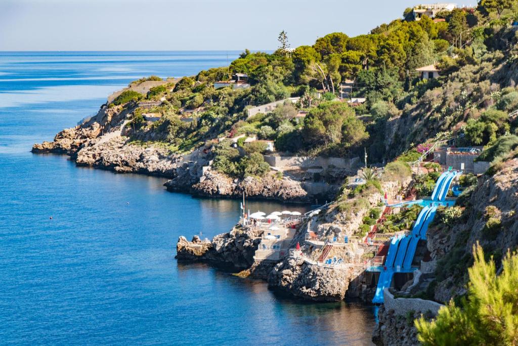 une île avec un pont bleu dans l'eau dans l'établissement CDSHotels Terrasini - Città del Mare, à Terrasini
