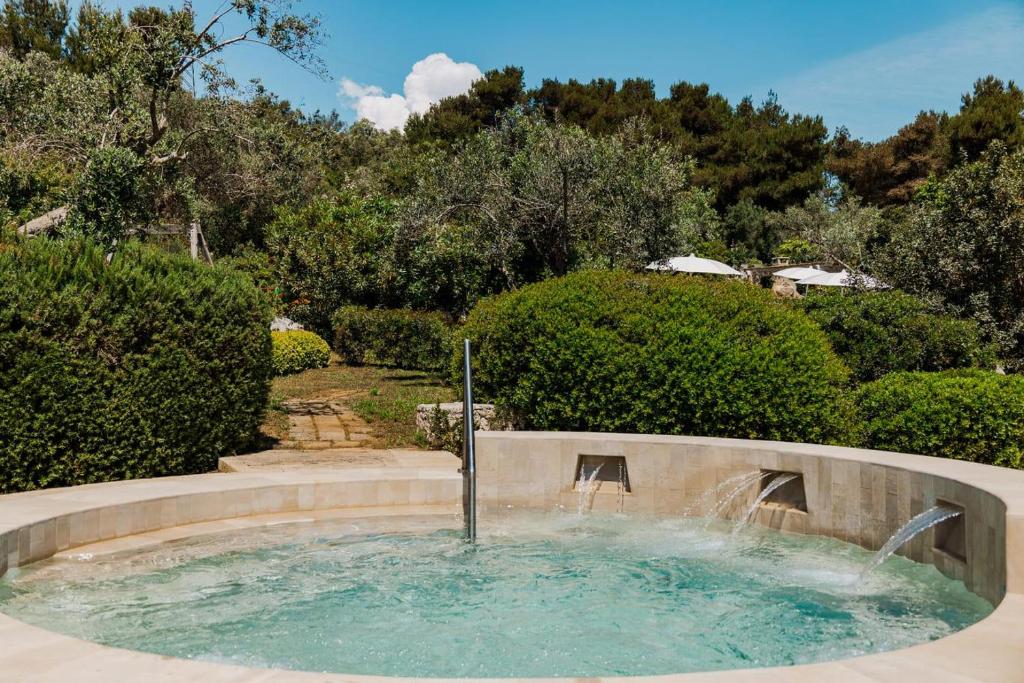 - une piscine avec une fontaine dans la cour dans l'établissement Marenea Suite Hotel - CDSHotels, à Marittima