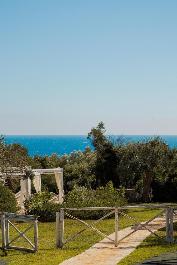 une clôture en bois et un chemin avec l'océan en arrière-plan dans l'établissement Marenea Suite Hotel - CDSHotels, à Marittima