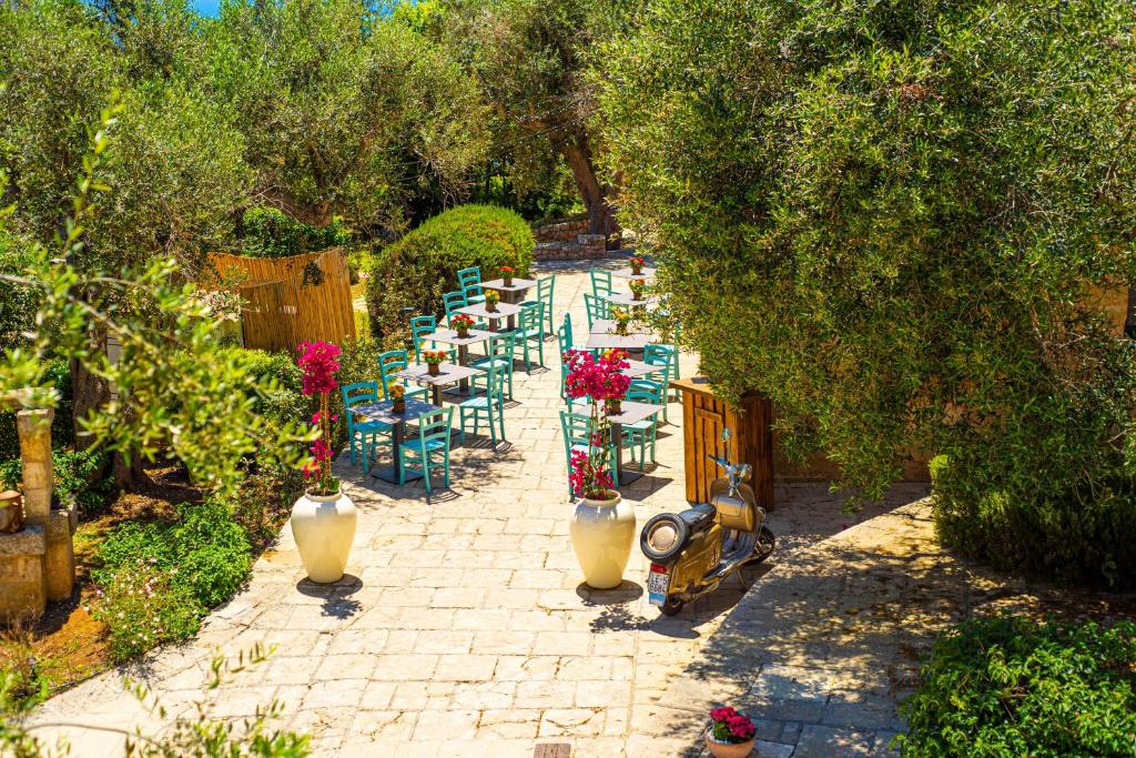 une rangée de tables et de chaises dans un jardin dans l'établissement Marenea Suite Hotel - CDSHotels, à Marittima 85 autres photos