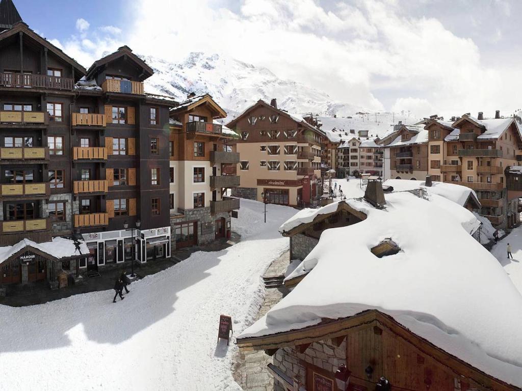 une personne est en train de skier sur une montagne enneigée dans l'établissement Résidence & Spa Les Sources de Marie - Arc 1950 Le Village, à Arc 1950