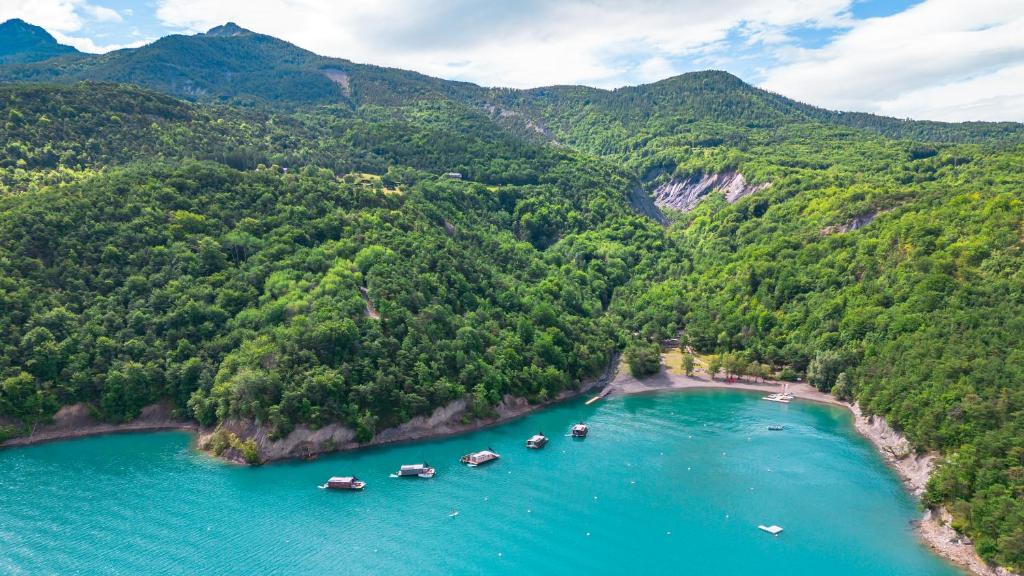 Vue aérienne d'une rivière avec des bateaux dans l'eau dans l'établissement Les Toues Cabanées du lac, à Le Sauze-du-Lac
